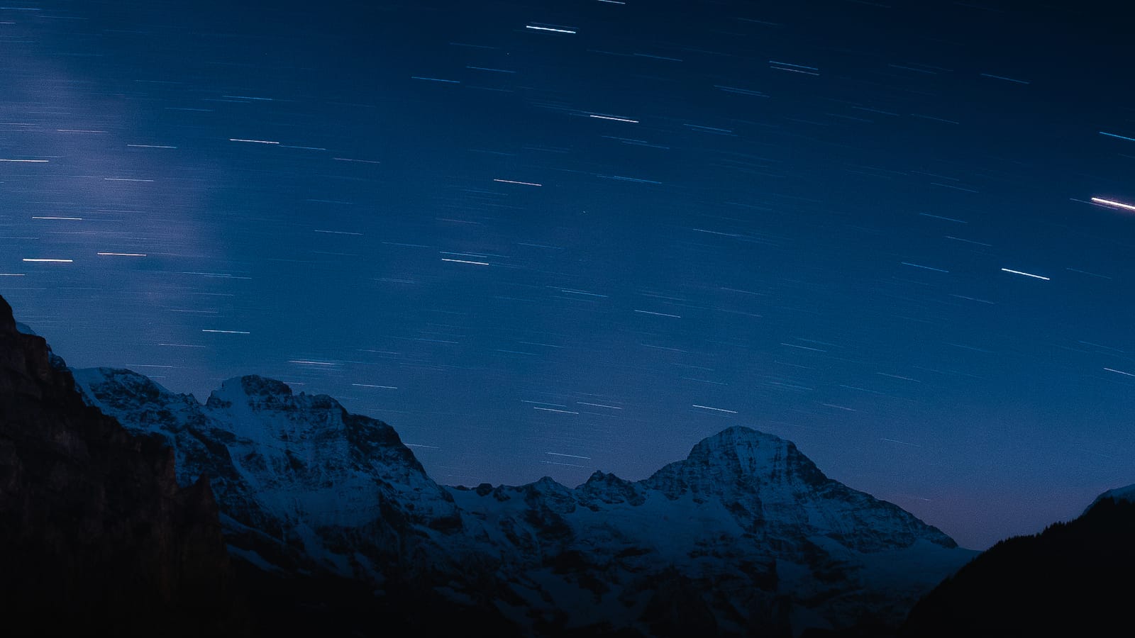 Star trails over a dark ridgeline.